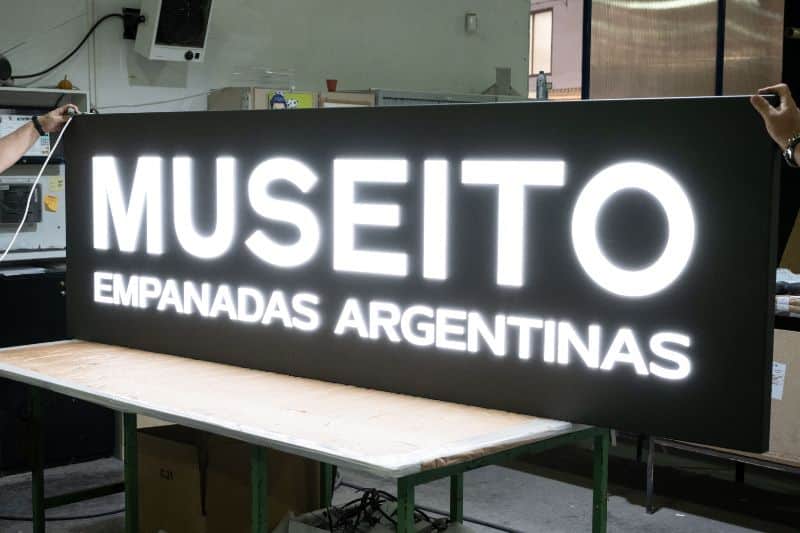 Panel oscuro con las palabras Museito Empanadas Argentinas iluminadas