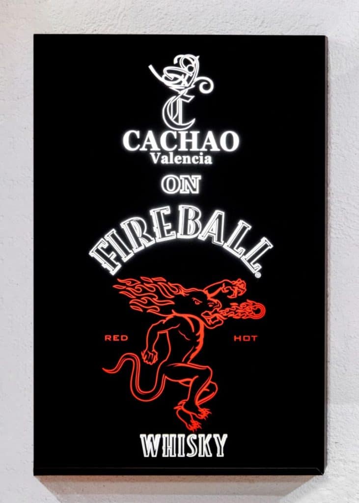 Panel negro con los nombres Cachao y Fireball y un dibujo rojo