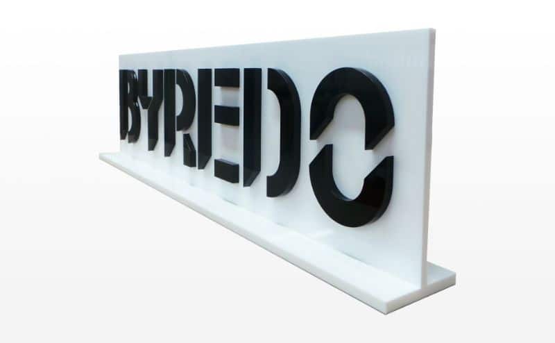 Letras negras Byredo sobre un soporte blanco con base