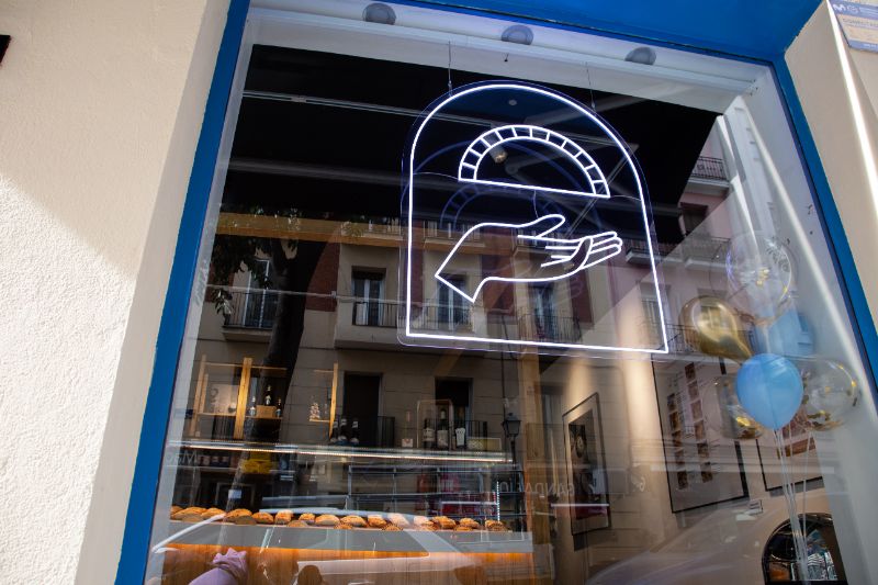 Dibujo luminoso de una empanada en el cristal de un escaparate