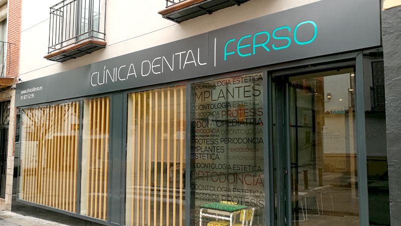 Nombre Clínica Dental Ferso sobre el acceso acristalado de una clínica
