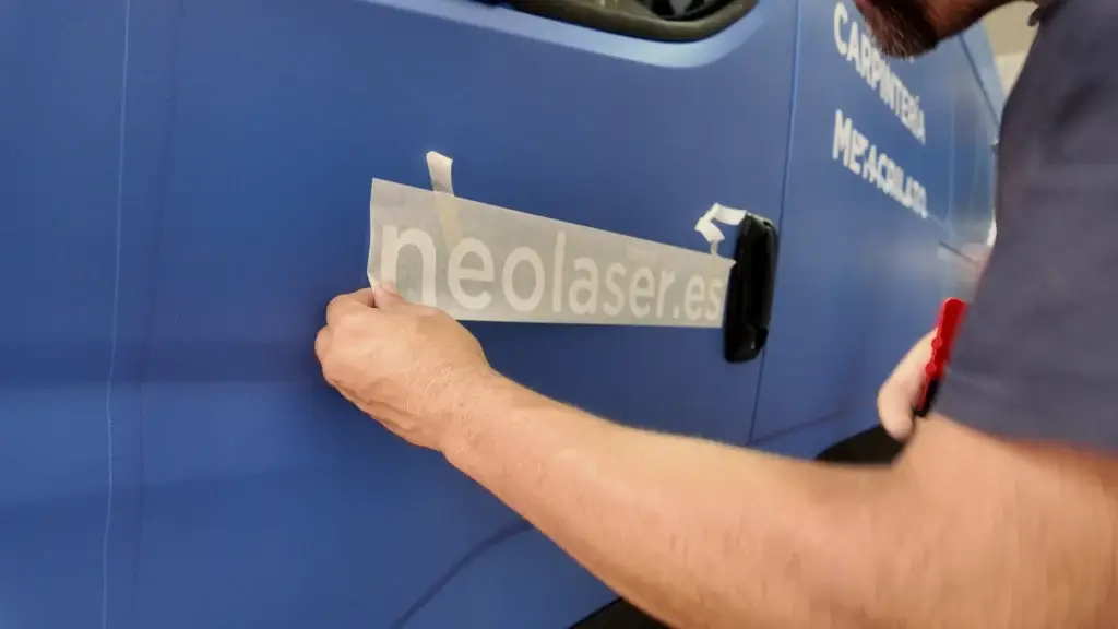 Aplicación manual del vinilo neolaser.es en el lateral de la furgoneta